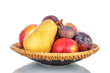 Fresh organic fruits, pear, apple, fig and juicy purple plum on a ceramic dish, close-up, isolated on white.