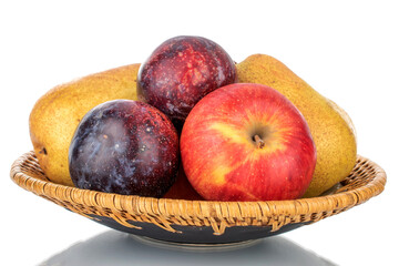 Fresh organic fruits, pear, apple, fig and juicy purple plum on a ceramic dish, close-up, isolated on white.