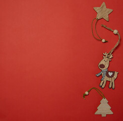 christmas card on a red background top view of a wooden deer, a Christmas tree, a star