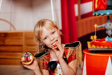 girl eating a cookie for her birthday in the style of the circus