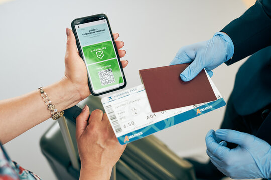Digital covid certificate. Covid vaccination digital pass. Woman passenger holding digital medical pass on her mobile phone, passport and airplane ticket. Traveler showing digital covid test
