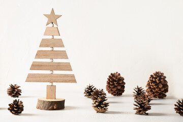 Creative wooden alternative Christmas tree and pine cones on white background. DIY. Concept eco...