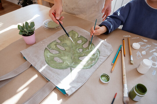 Mother and son painting leaf