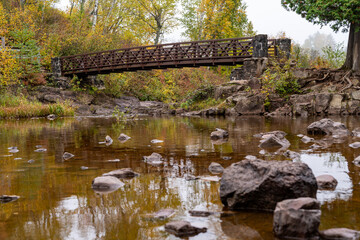 Fototapeta na wymiar Bridge crossing the Gooseberry River in fall, at Gooseberry Falls State Park Minnesota