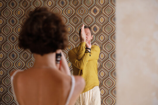 Man showing yoga pose to woman
