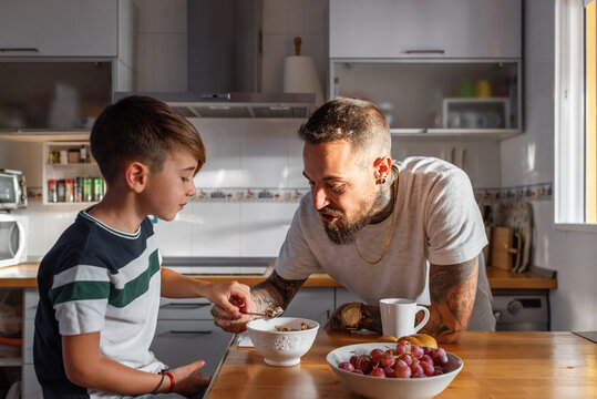 Father trying breakfast of son