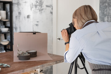 Female artisan taking pictures of crockery