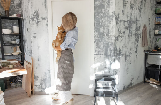 Craftswoman with cat in pottery