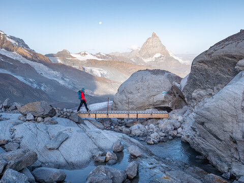 Girl hiking over bridge near Matterhorn.