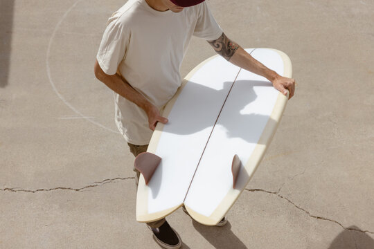 person holding surfboard on concrete