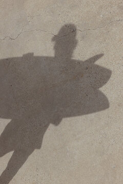 shadow of person holding surf board