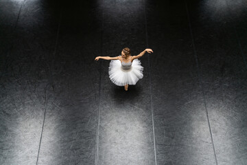 Female ballet dancer posing inside dance hall