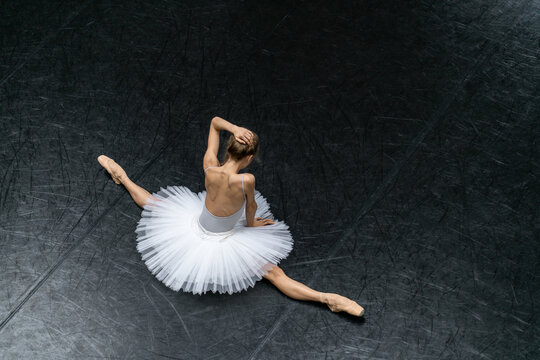 Naklejki Female ballet dancer posing inside dance hall