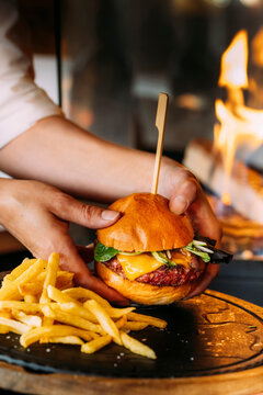 An unrecognizable person holding a delicious BBQ Burger