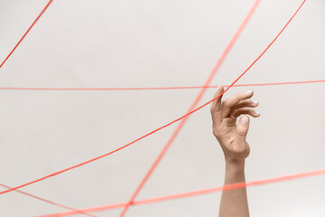 Female arm with red threads which symbolized control and restriction