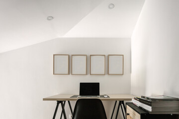 Minimalist home office with white frames on the wall