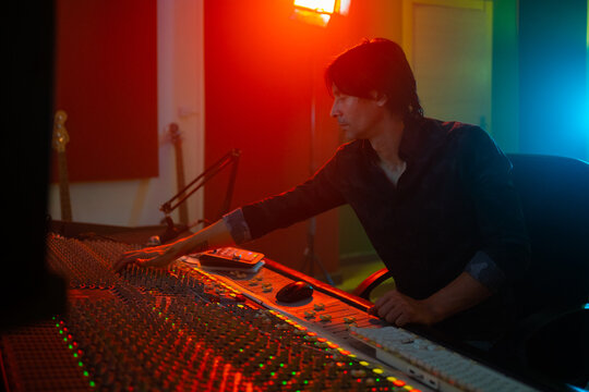 Professional Music Producer With A Mixer Sound Desk.
