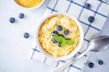 Corn porridge with fresh blueberries in a bowl
