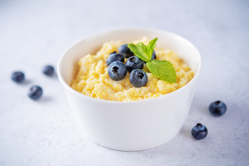 Corn porridge with fresh blueberries in a bowl
