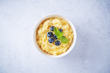 Corn porridge with fresh blueberries in a bowl