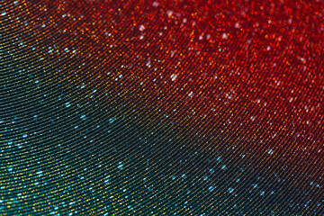 Wavy shimmering background with metallic grains of sand. Texture with grain and sequins close-up. Gradient two-color red-green image - 463157630