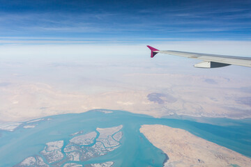Fototapeta na wymiar Aerial view of the desert from the airplane porthole. Travel concept