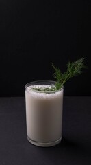 Turkish or Azerbaijan traditional Drink Ayran or Kefir dill in a glass on a wooden table on a black background. Fermented milk drink for diet. Copy space. the concept of healthy nutrition.
