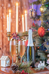 Glasses of champagne and gifts composition with lit up candelabra .