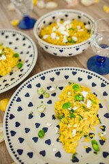 Yellow rice with greens on a cute plate with blue hearts and a table decorated with flower petals