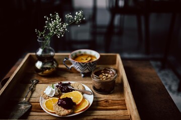 Room service tray at hotel for breakfast_ cookies, jam, chocolate mousse, orange fruit, tea