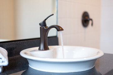 Water running from the faucet on a modern vessel sink