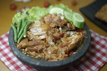 close up of ayam penyet traditional spicy sauce or sambal. fried chicken