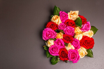 Composition of fresh multicolored roses on ceramic stand