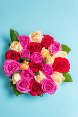 Composition of fresh multicolored roses on ceramic stand