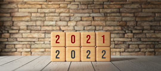 cubes with message 2021 and 2022 in front of a brick wall