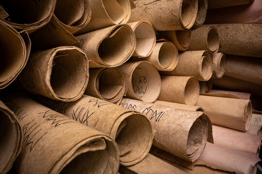 Ancient scrolls stacked on pile. Old scroll library.