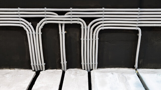 Electrical cables and pipes on house concrete ceiling, modern wiring
