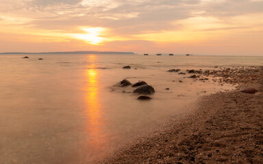 Obraz premium Sunset / sunrise over a lake with a beach