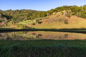 Obraz premium Farm fields with forest reflected in a lake
