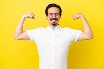 Young caucasian man isolated on yellow background doing strong gesture