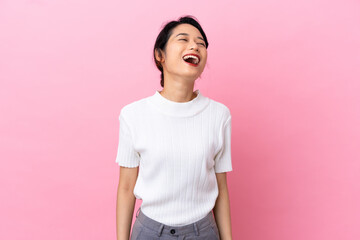 Young Vietnamese woman isolated on pink background laughing
