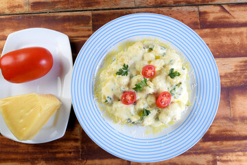 plate of pasta and gnocchi in béchamel sauce with tomato cheese oil, viata image from above with space for text