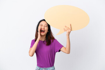 Young Vietnamese woman isolated on white background holding an empty speech bubble and shouting