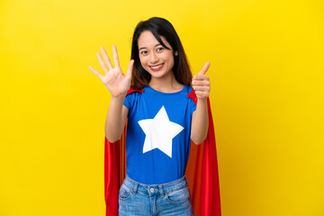 Super hero Vietnamese woman isolated  on yellow background counting six with fingers