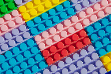 children's play background: the plane of plastic multi-colored bricks, blur, selective focus