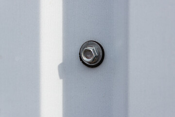 Metal self-tapping screw screwed into the fence.