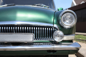 Obraz na płótnie Canvas Beautiful green retro car on street, closeup