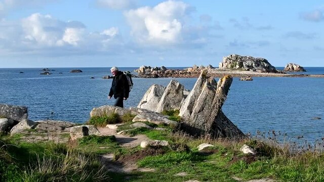 Hiker walking on the beautifful coastline of Brittany in France
