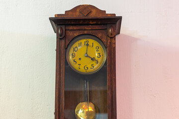 Old large wooden clock with a pendulum.