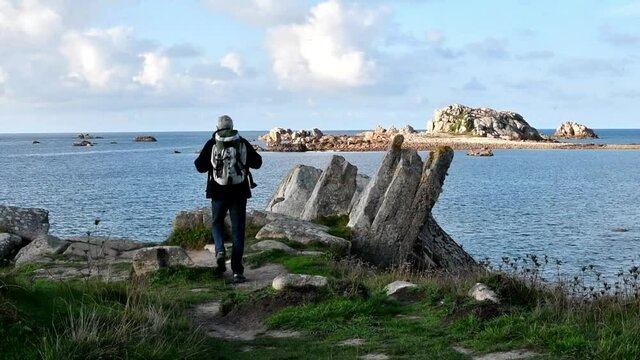 Hiker walking on the beautifful coastline of Brittany in France